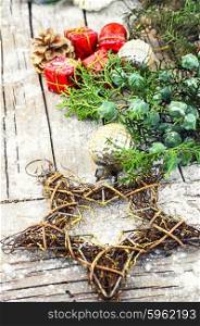 Winter scenery with thuja. Woven wire Christmas star on wooden background with snow