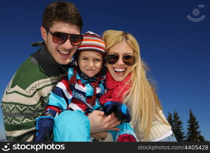 Winter season. Happy family having fun on fresh snow on vacation.