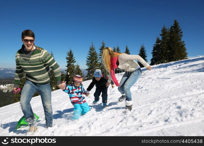 Winter season. Happy family having fun on fresh snow on vacation.