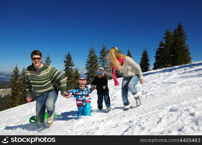 Winter season. Happy family having fun on fresh snow on vacation.