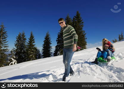 Winter season. Happy family having fun on fresh snow on vacation.