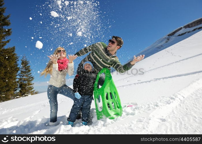 Winter season. Happy family having fun on fresh snow on vacation.