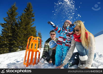 Winter season. Happy family having fun on fresh snow on vacation.