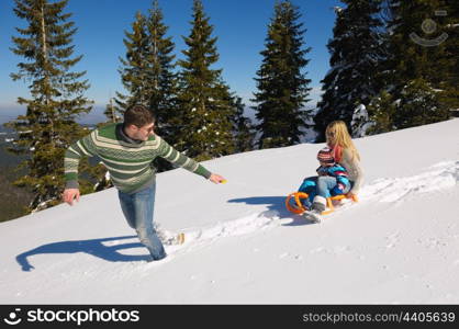 Winter season. Happy family having fun on fresh snow on vacation.