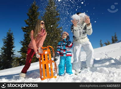 Winter season. Happy family having fun on fresh snow on vacation.