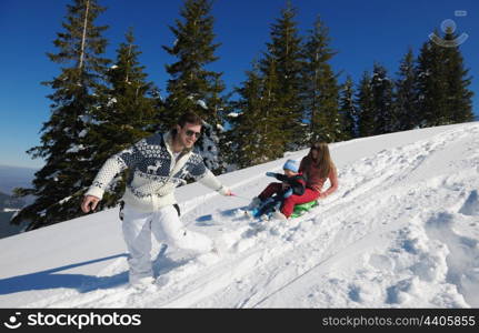 Winter season. Happy family having fun on fresh snow on vacation.