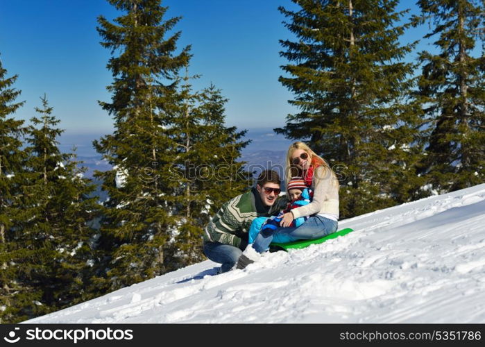 Winter season. Happy family having fun on fresh snow on vacation.