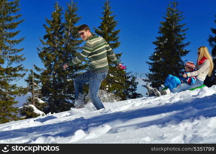 Winter season. Happy family having fun on fresh snow on vacation.