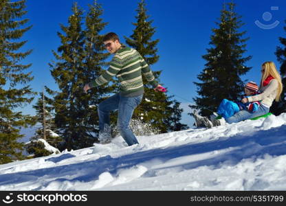 Winter season. Happy family having fun on fresh snow on vacation.