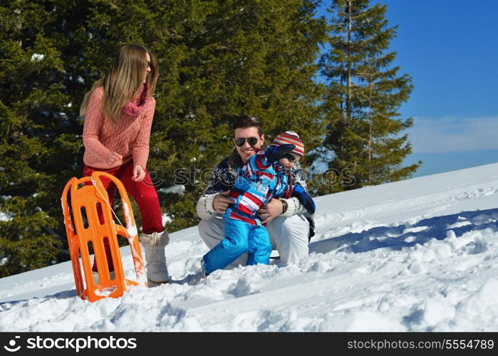 Winter season. Happy family having fun on fresh snow on vacation.