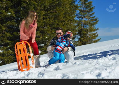 Winter season. Happy family having fun on fresh snow on vacation.