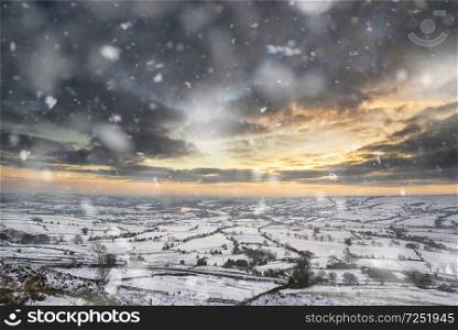 Winter sky over snow covered Winter landscape in Peak District at sunset in heavy snow storm. Landscapes