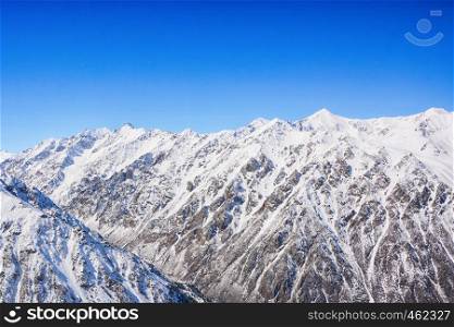 Winter snow covered mountain peaks. Tourists Ala-Archa National Park in Kyrgyzstan.