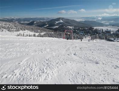 Winter snow covered mountain ski resort slope . Magnificent sunny day on picturesque alpine resort, Dragobrat, Ukraine, Carpathian Mountains. People unrecognizable.