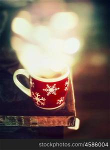 Winter snowflakes Cup with hot tea and bokeh on dark rustic table, side view