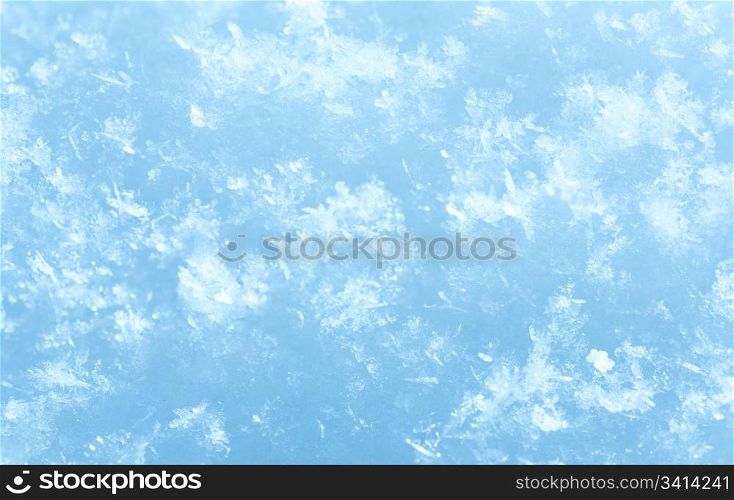 Winter snowflakes on white snow surface. Composite macro photo with considerable depth of sharpness.