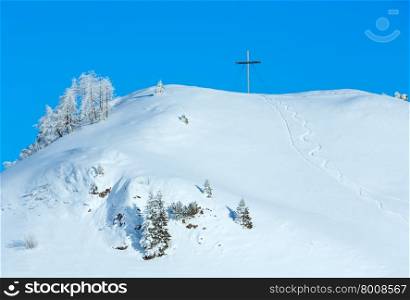 Winter snowy hill with cross on top.