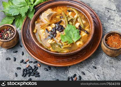 Winter soup with meat and black beans. Bowl of delicious meat soup