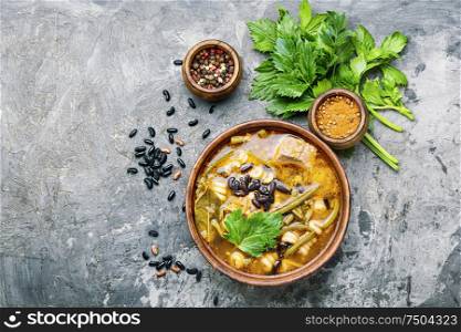 Winter soup with meat and black beans. Bowl of delicious meat soup