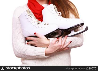 Winter sport equipment concept. Close up picture of ice skates. Woman with white jumper.. Close up woman holds ice skates.