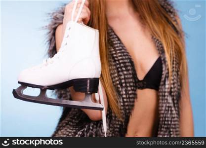 Winter, sport, people concept. Attractive lady with ice skates. Young woman wearing bra. Sexy woman holding ice skates
