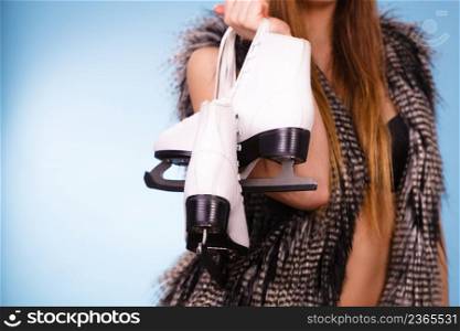 Winter, sport, people concept. Attractive lady with ice skates. Young woman wearing fur cap.. Attractive lady with ice skates.
