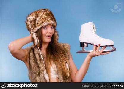 Winter, sport, people concept. Attractive lady with ice skates. Young woman wearing fur cap.. Attractive lady with ice skates.