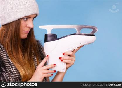 Winter, sport, people concept. Attractive lady with ice skates. Young woman wearing woolen cap.. Attractive lady with ice skates.