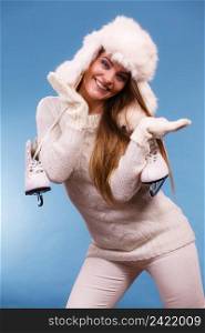 Winter sports clothing concept. Attractive lady with ice skate. Young woman wearing white cozy outfit.. Attractive lady with ice skate.