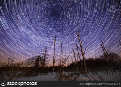 Winter starry night landscape with circle star trails