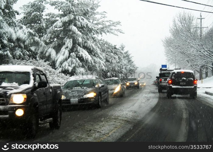 Winter storm, cars on the road while the snow falls.