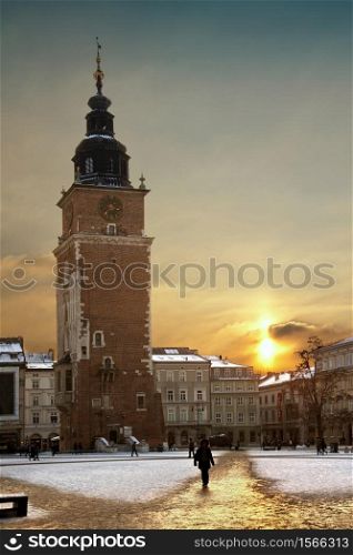 Winter sunlight and the Town Hall Tower at dusk in the main square (Rynek Glowny) in the old town district of Krakow in Poland.