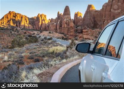 Winter sunrise driving on a highway through Arches National Park near Moab in Utah, travel, recreation and vacation concept.