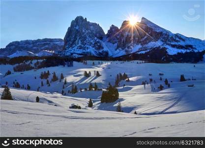 Winter sunrise over Alpe di Siusi with view on Sassolungo and Sassopiatto, Dolomites, Italy. Winter sunrise on Alpe di Siusi with rising sun over Sassolungo and Sassopiatto, Dolomites, Italy