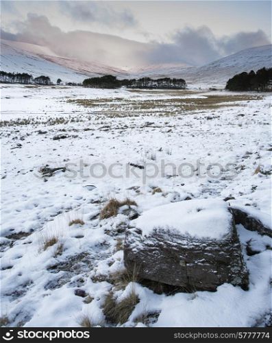 Winter sunrise over mountain range landscape with snow covered ground