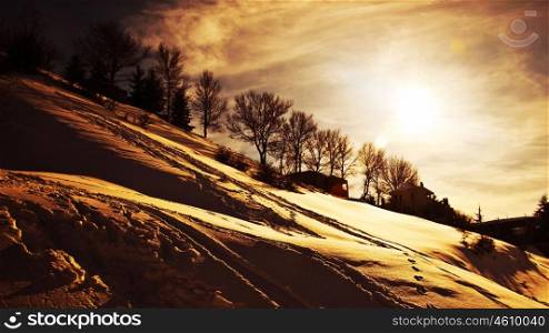 Winter sunset, beautiful mountains landscape, village covered with snow, cold weather wintertime seasonal nature, dramatic sky with warm sun light