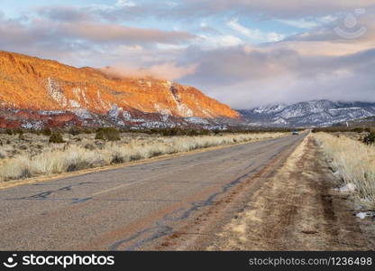 Winter sunset over a highway through Castle Valley in the Moab area, Utah, with La Sal Mountains in background, recreation and travel concept