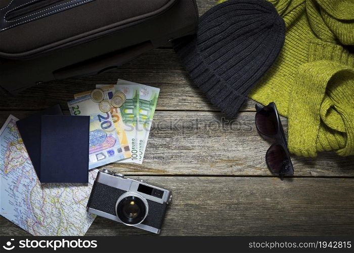 Winter travel stuff on a wooden background with suitcase