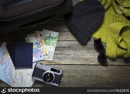 Winter travel stuff on a wooden background with suitcase