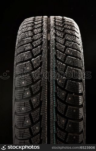 Winter tyre cover in snow on a black background. Tyre cover