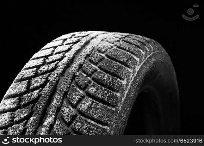 Winter tyre cover in snow on a black background. Tyre cover