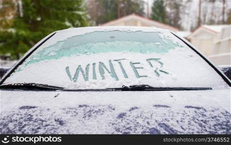 Winter written in snow on car snow covered windscreen
