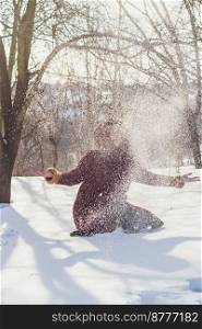Wintertime leisure scenic photography. Throwing snow in air. Picture of woman with winter forest on background. High quality wallpaper. Photo concept for ads, travel blog, magazine, article. Wintertime leisure scenic photography