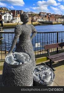 Wire statue of a fishwife at the harbor in the port of Whitby on the North Yorkshire coast in the northeast of England.