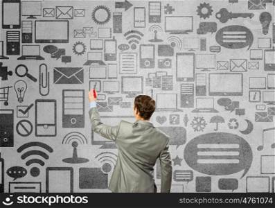 Wireless connection. Back view of businessman drawing connection concept on wall