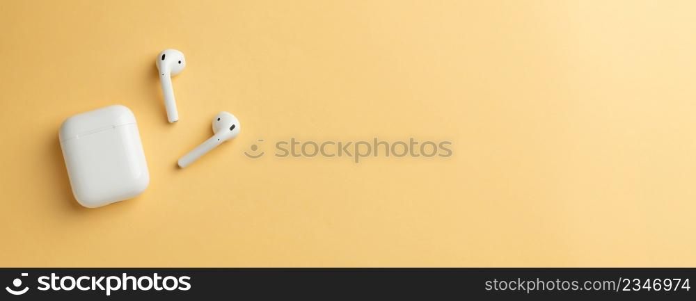 Wireless headphones and charging box, photographed leaving empty space on the right side of the photo