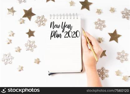 Wish list for Cristmas and New Year. Holiday decorations and ruled notebook with wish list on white desk, flat lay top view. Christmas flat lay scene with golden decorations