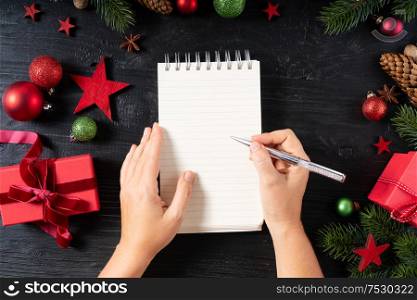 Wish list for Cristmas and New Year with red git boxes, Christmas celebration and gift giving concept, copy space on empty page. Christmas flat lay scene with golden decorations