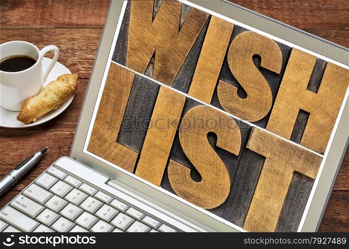 wish list word abstract typography - text in letterpress wood type on a laptop with a cup of coffee