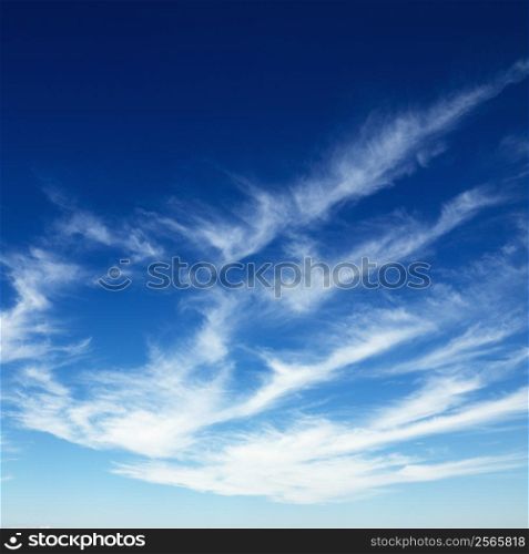 Wispy cirrus clouds in blue sky.